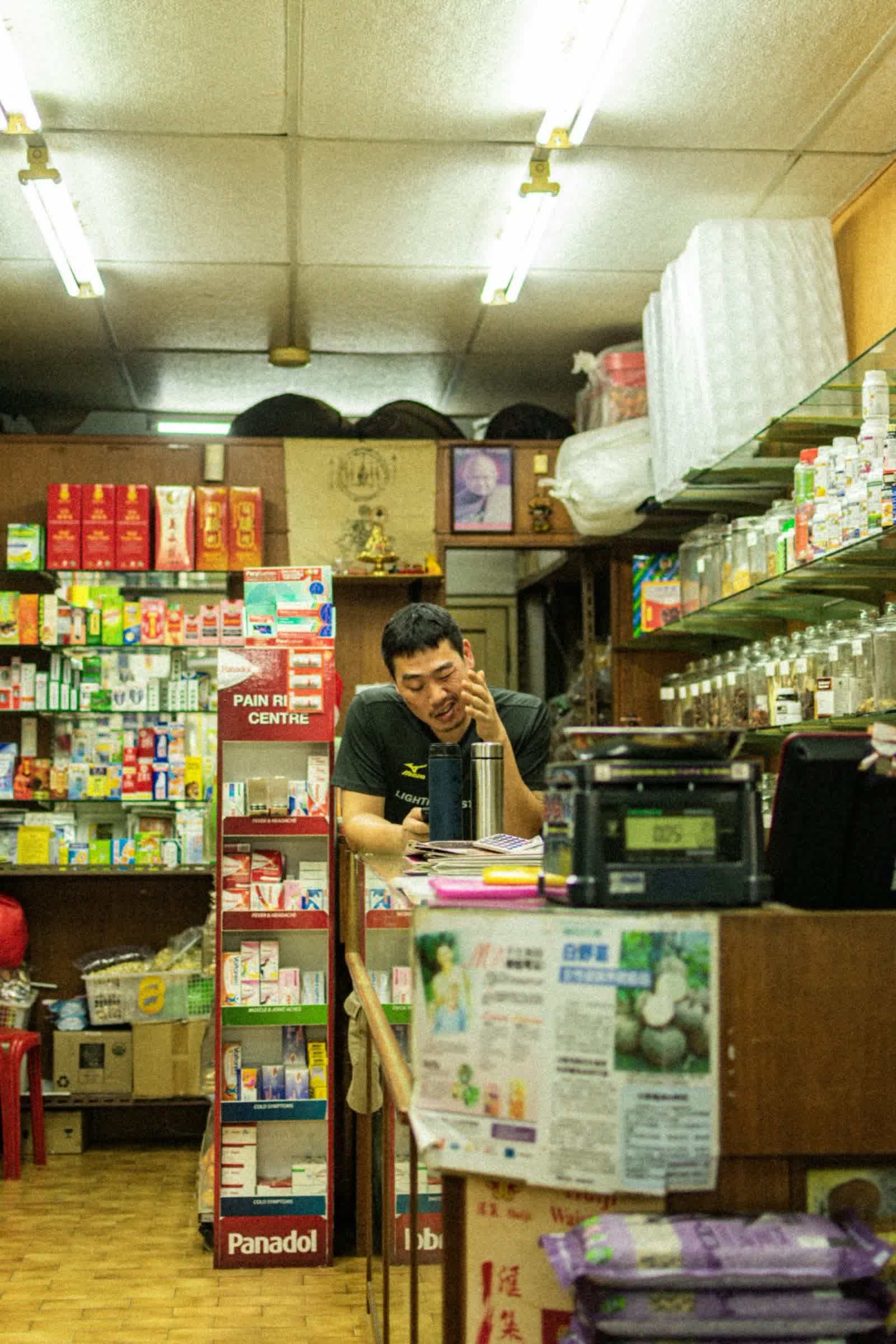 A shop owner behind the counter of his store